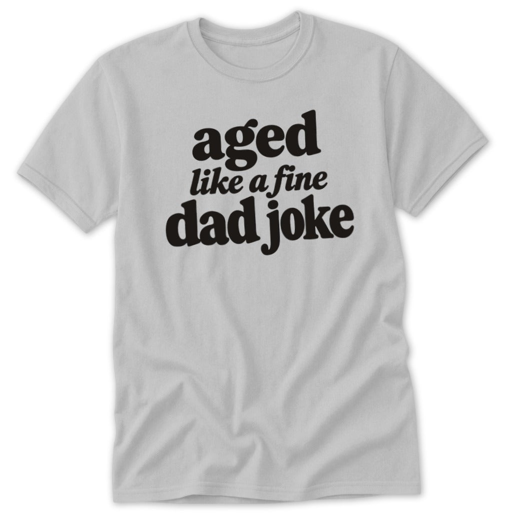 Light gray crewneck t-shirt featuring black text that reads aged like a fine dad joke