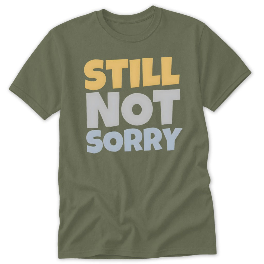 Olive green short-sleeved t-shirt featuring the text STILL NOT SORRY printed in yellow, white, and light blue.