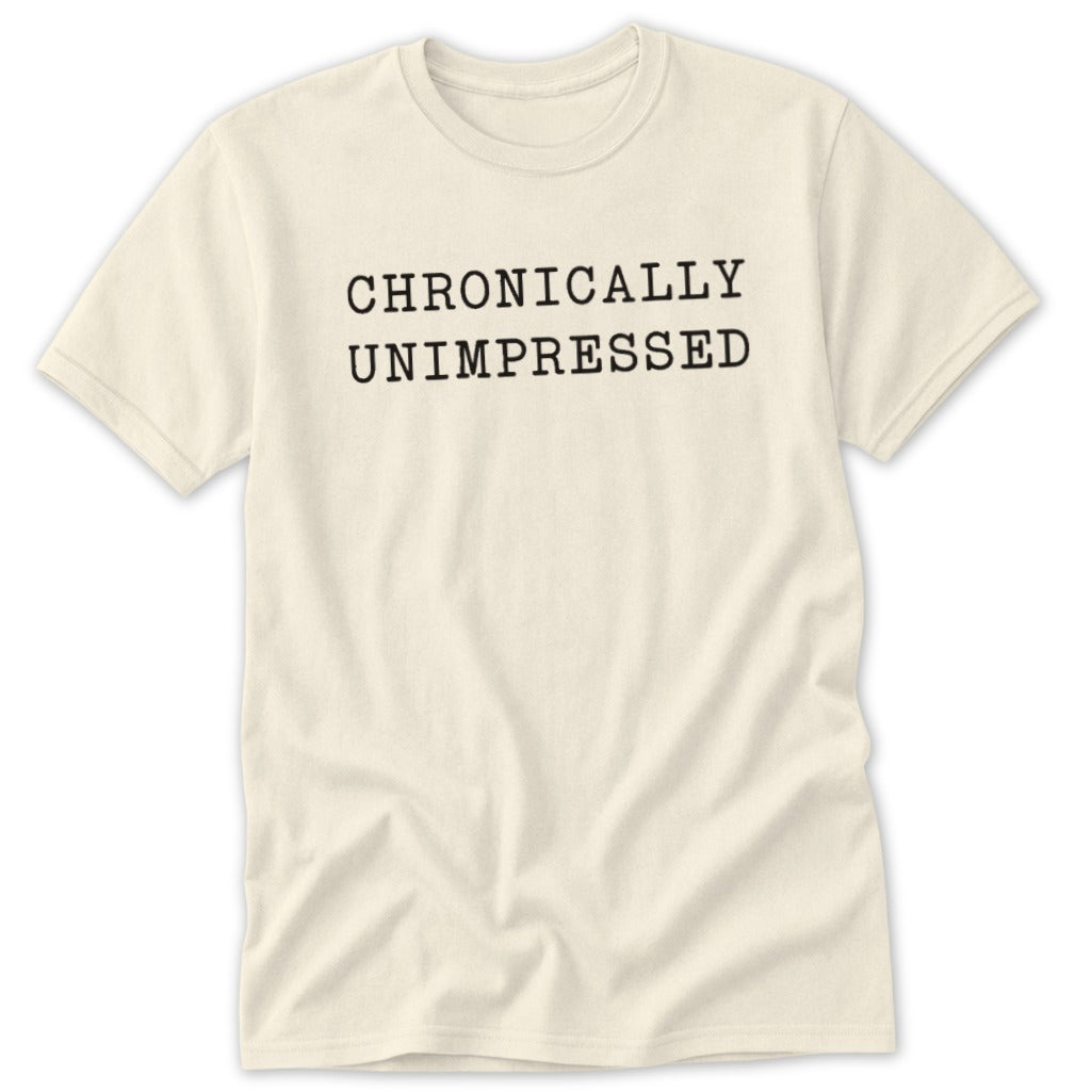 Cream t-shirt with black text that reads "CHRONICALLY UNIMPRESSED".