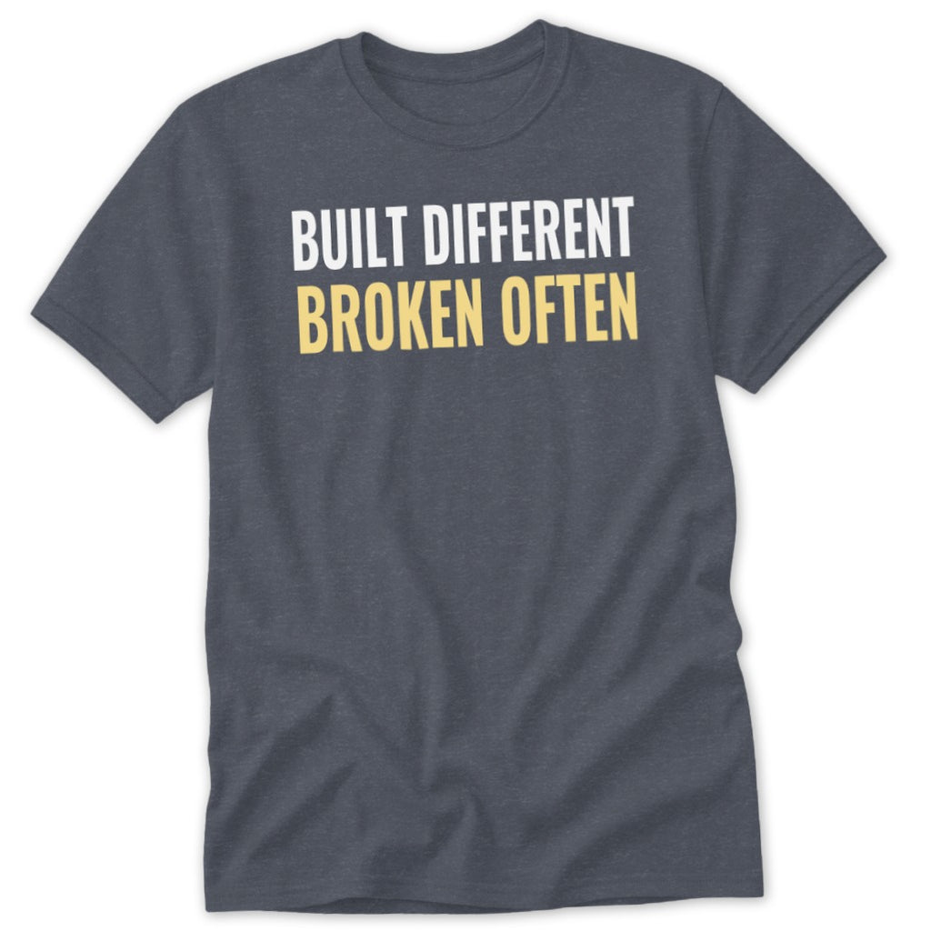 Gray t-shirt with white text "BUILT DIFFERENT" and yellow text "BROKEN OFTEN".