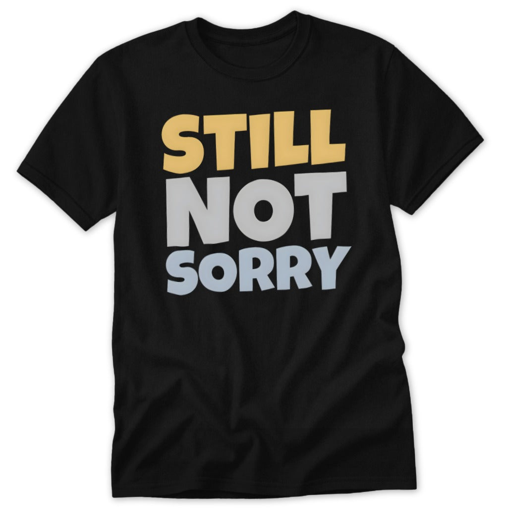 Black t-shirt featuring the stacked text "STILL NOT SORRY" in yellow, grey, and light blue.