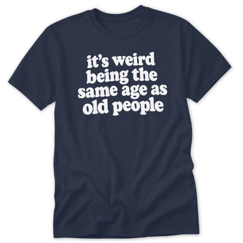 A dark blue short-sleeve t-shirt with white text that reads it's weird being the same age as old people.
