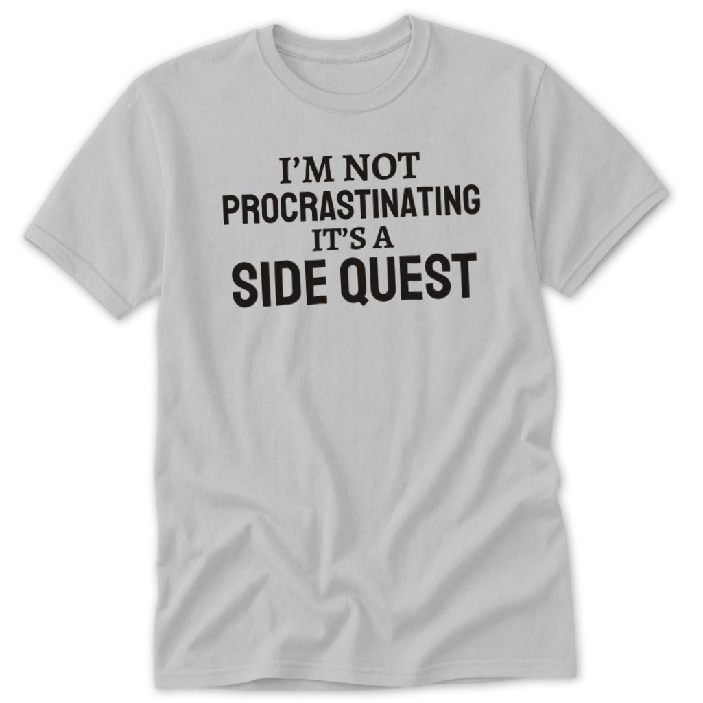 Light grey t-shirt with black text reading "I'M NOT PROCRASTINATING IT'S A SIDE QUEST".