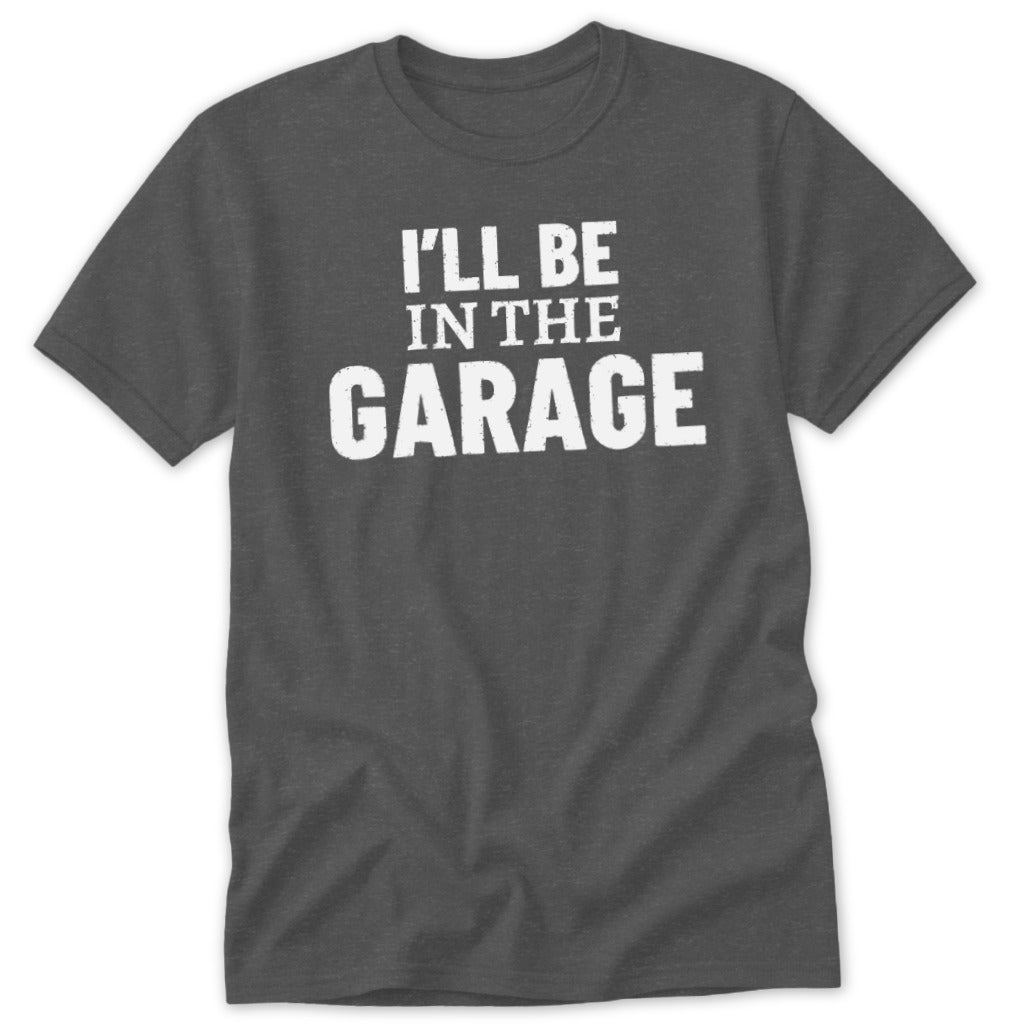 Dark gray t-shirt with white text that reads "I'LL BE IN THE GARAGE."