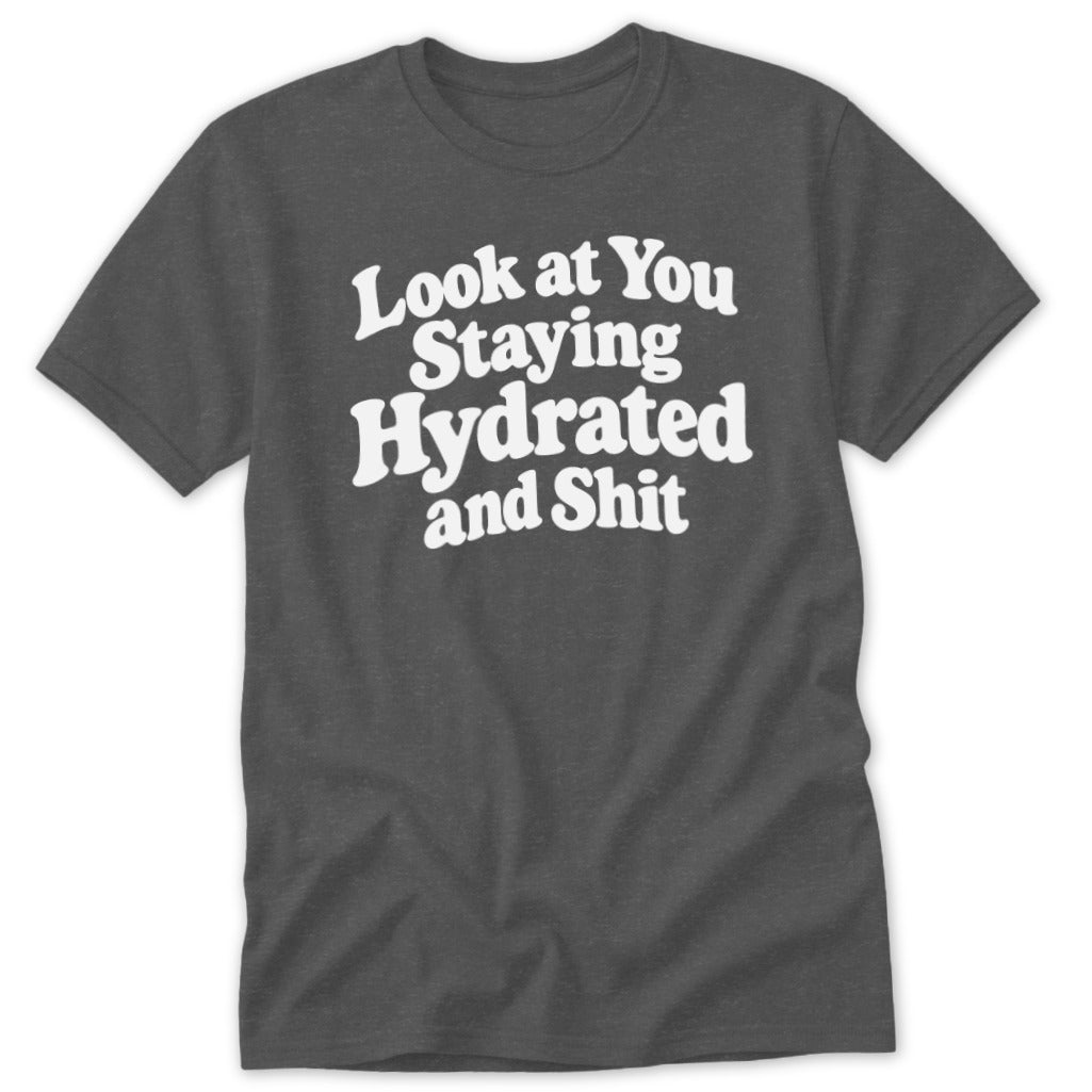 A dark gray crewneck t-shirt featuring the white text Look at You Staying Hydrated and Shit centered on the chest.