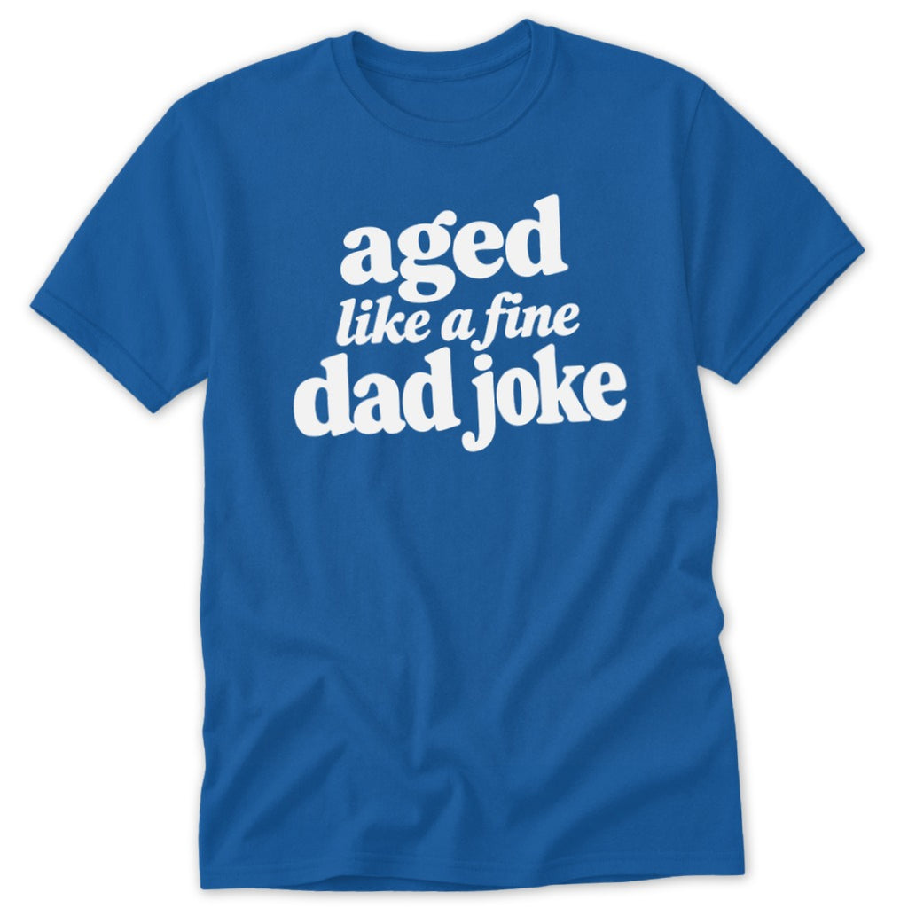 A blue short-sleeved t-shirt with white text reading aged like a fine dad joke on the chest.