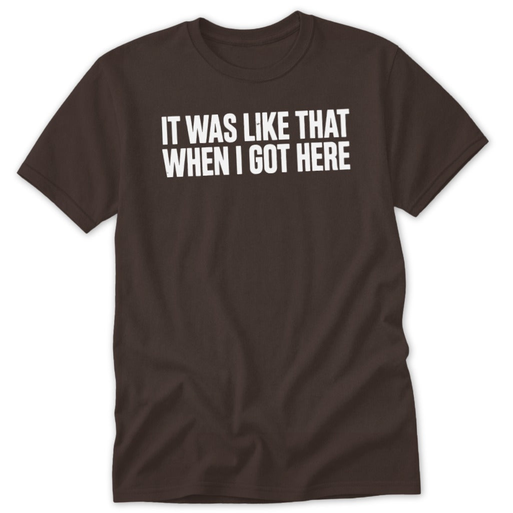 Brown t-shirt with white text "IT WAS LIKE THAT WHEN I GOT HERE".