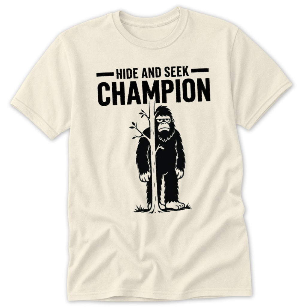 Cream t-shirt with Bigfoot behind a tree and text "Hide and Seek Champion".