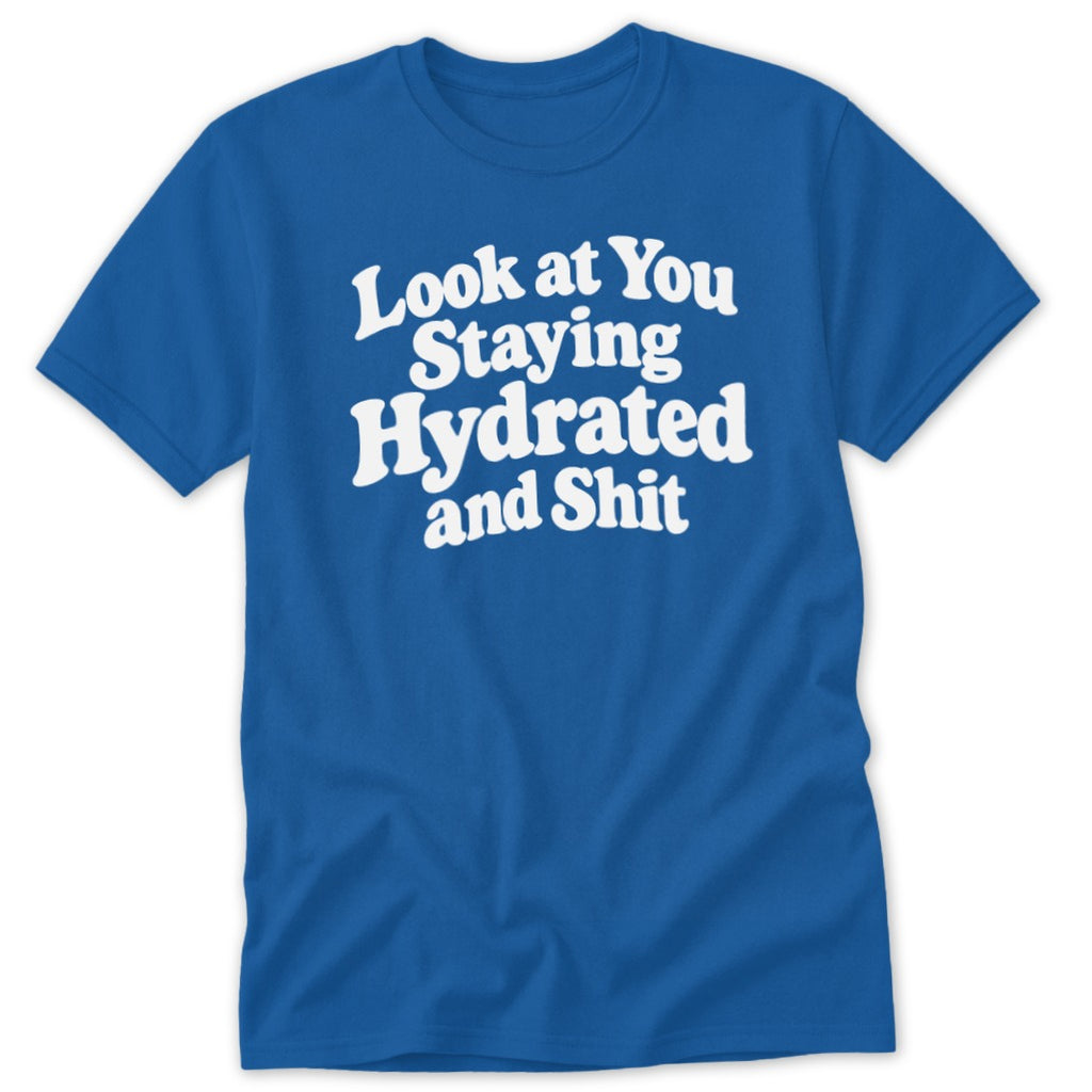 A blue short-sleeved t-shirt with white text reading Look at You Staying Hydrated and Shit.