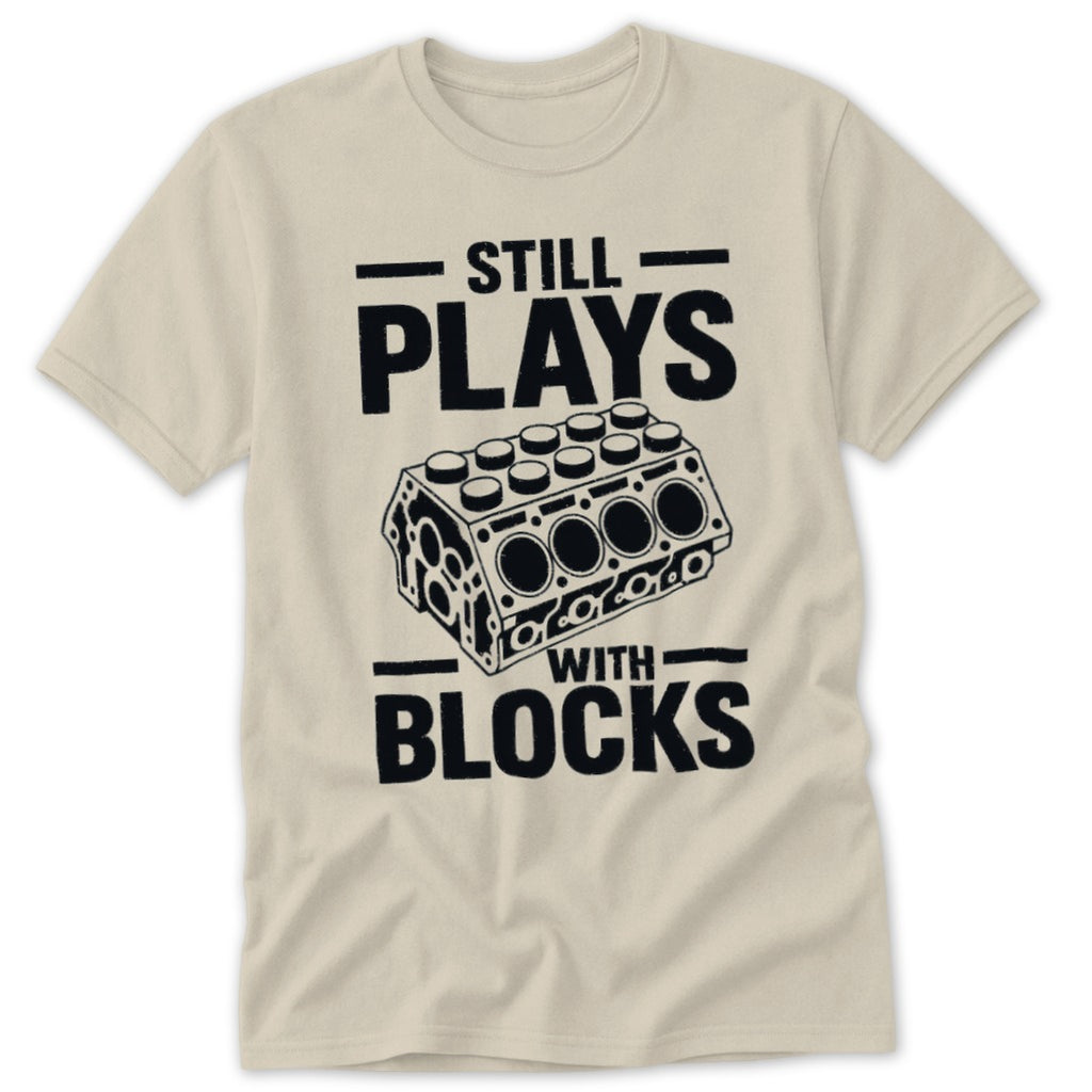T-shirt with black text "STILL PLAYS WITH BLOCKS" and engine block graphic.