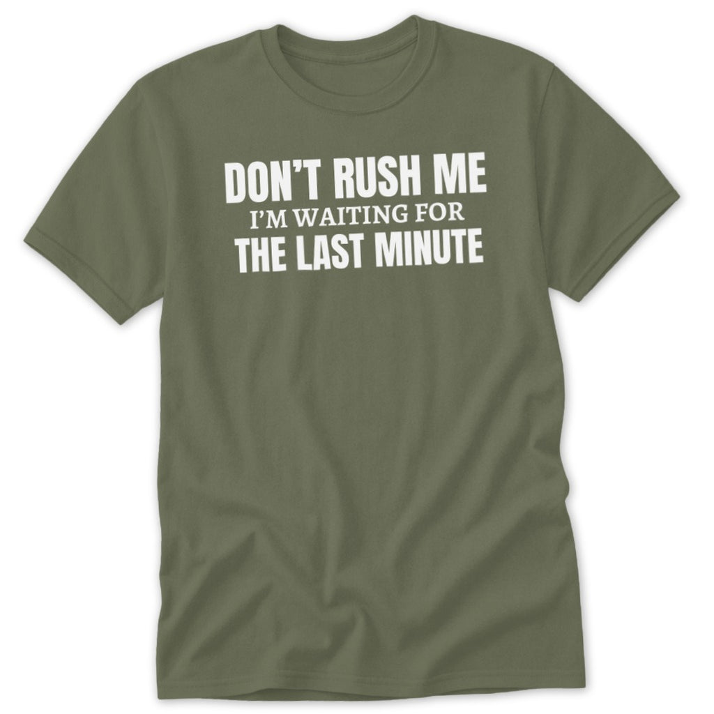 Olive green t-shirt with white text that says "DON'T RUSH ME I'M WAITING FOR THE LAST MINUTE".