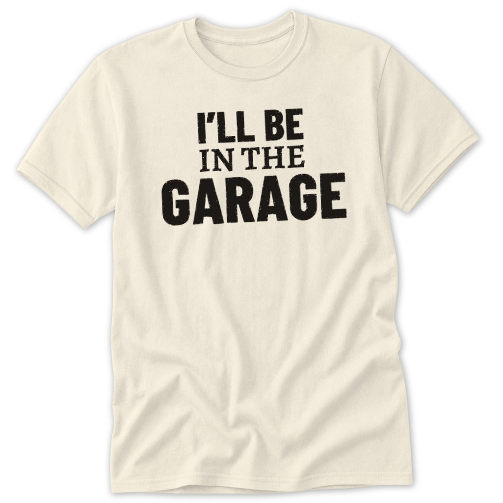 Cream t-shirt with "I'LL BE IN THE GARAGE" text in black.