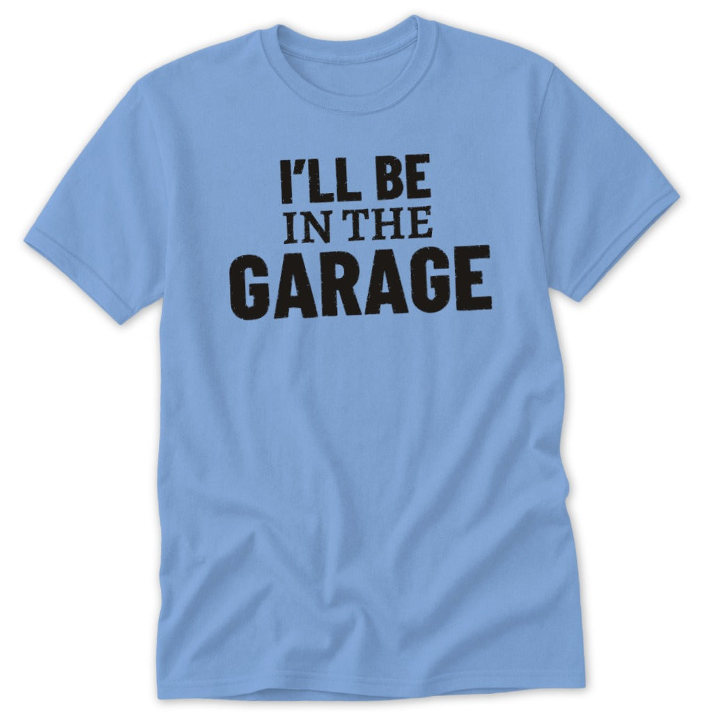 Light blue t-shirt with black text that reads "I'LL BE IN THE GARAGE".