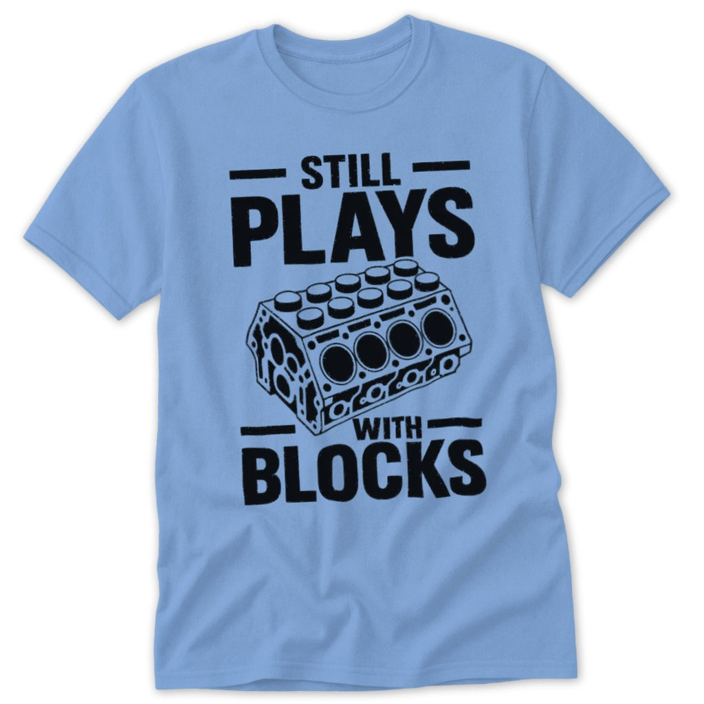 Light blue t-shirt with black text "Still Plays With Blocks" and engine block graphic.