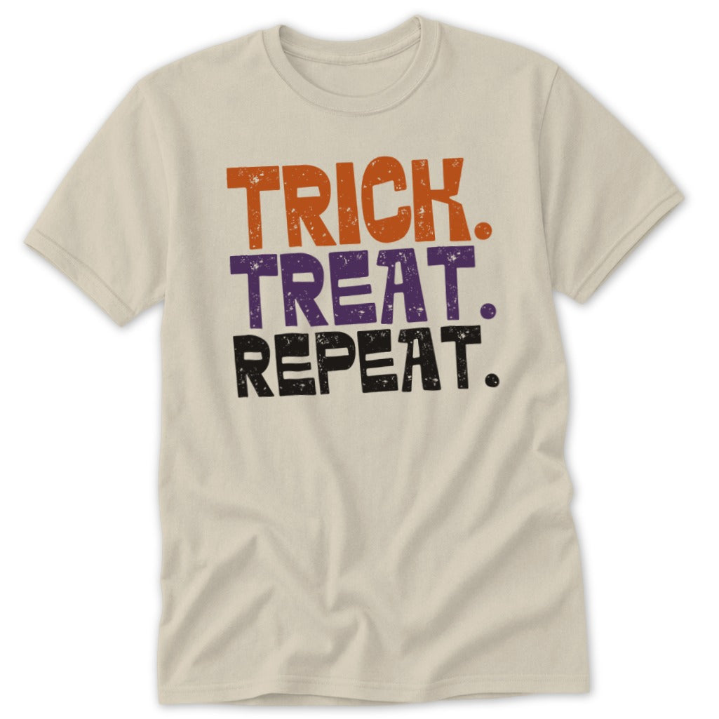 Cream t-shirt with "Trick. Treat. Repeat." text in orange, purple, and black.