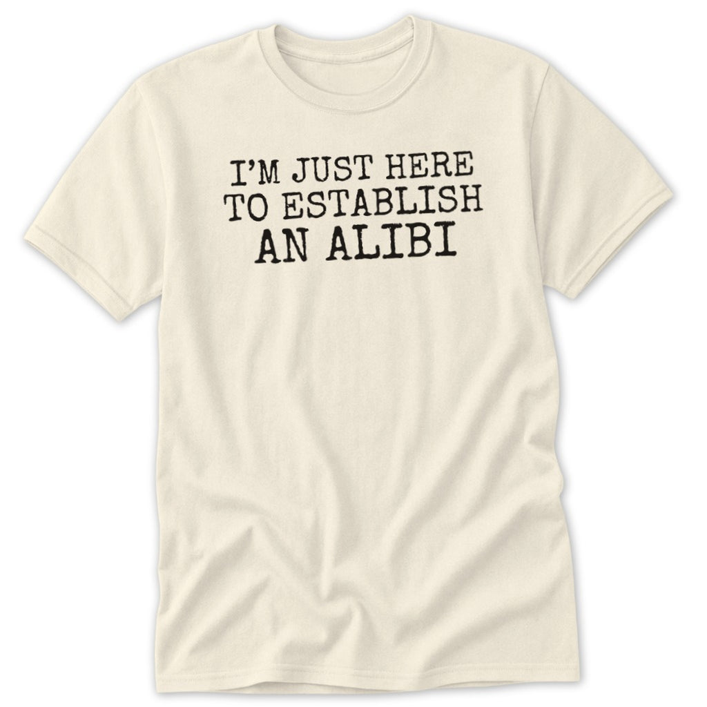 Cream t-shirt with black text that reads "I'M JUST HERE TO ESTABLISH AN ALIBI".