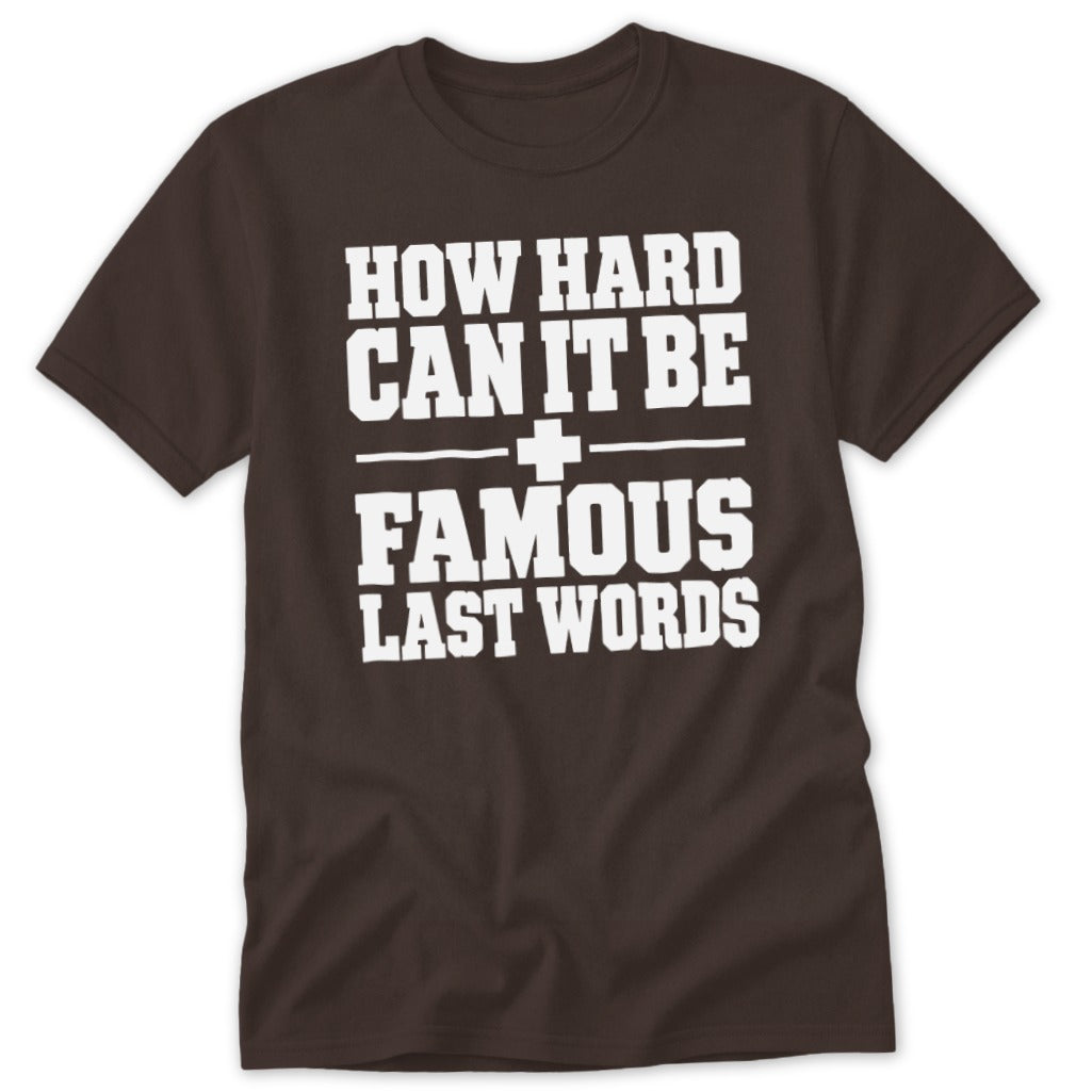A brown short-sleeve t-shirt with white block lettering that reads "How hard can it be famous last words".
