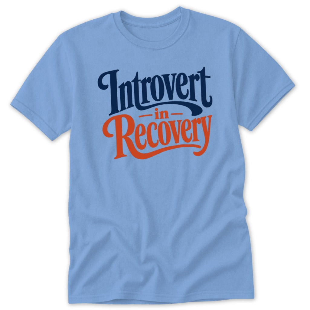 A light blue t-shirt printed with the dark blue and orange text Introvert in Recovery.