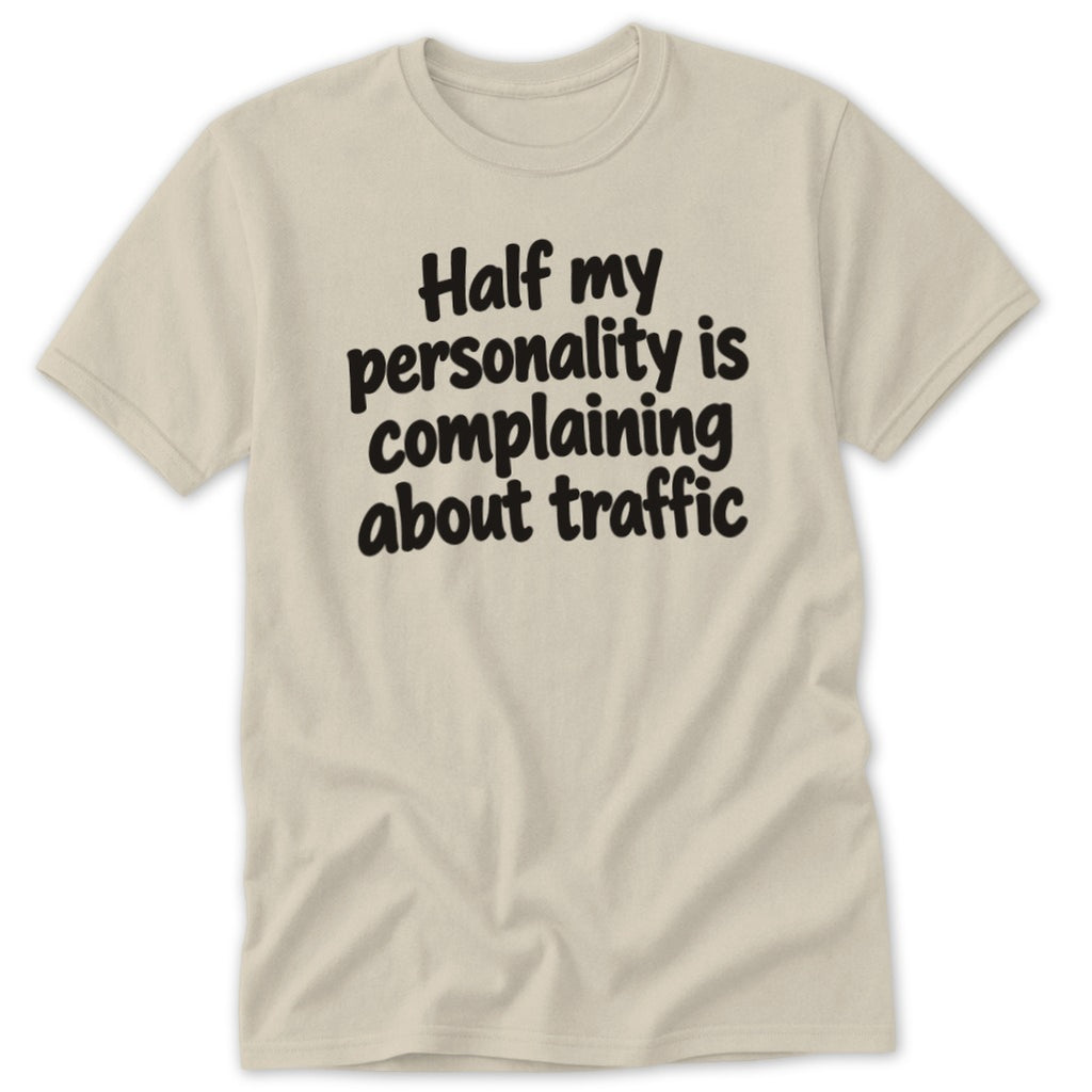 A beige t-shirt featuring the black text Half my personality is complaining about traffic centered on the chest.