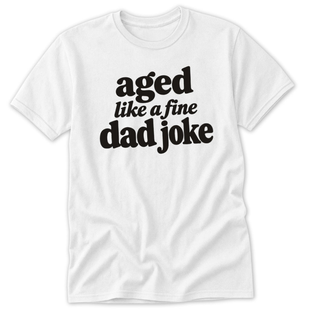 A white short-sleeved t-shirt featuring the black text "aged like a fine dad joke" on the chest.