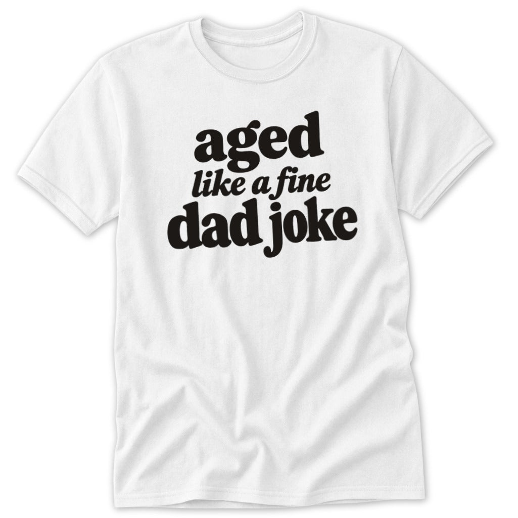A white short-sleeved t-shirt featuring the black text "aged like a fine dad joke" on the chest.