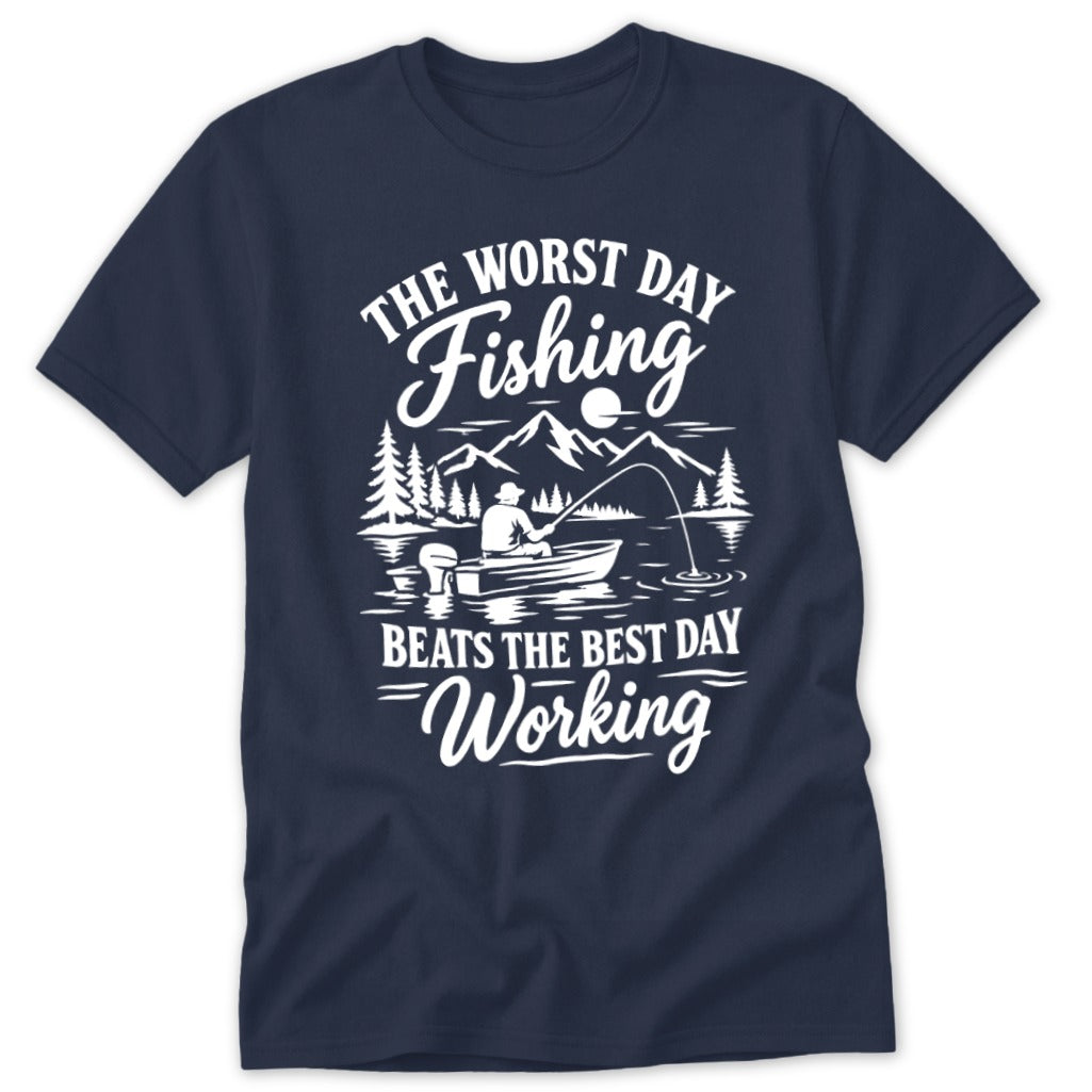 Navy blue t-shirt featuring a white graphic of a person fishing from a boat with mountains and trees in the background, accompanied by text that reads "The worst day fishing beats the best day working".