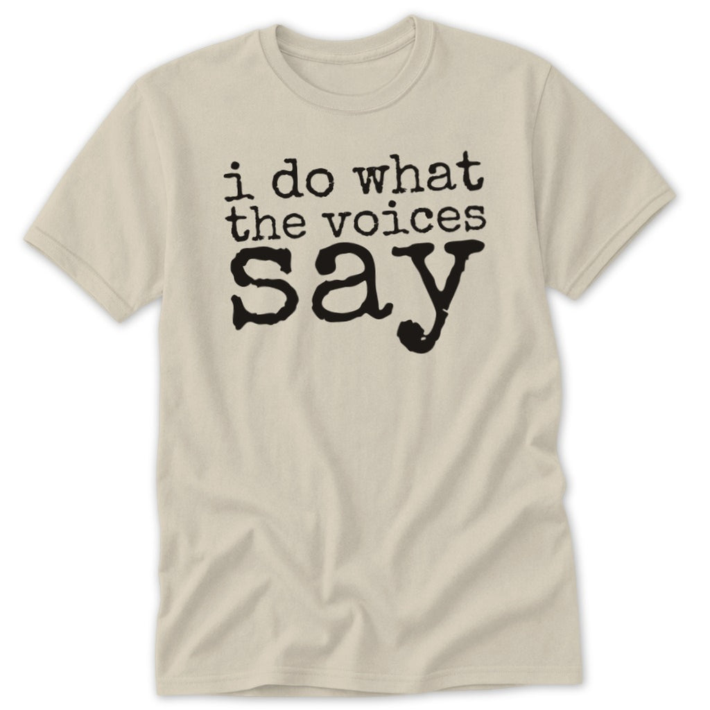 A light beige crewneck t-shirt with black text that reads "i do what the voices say".