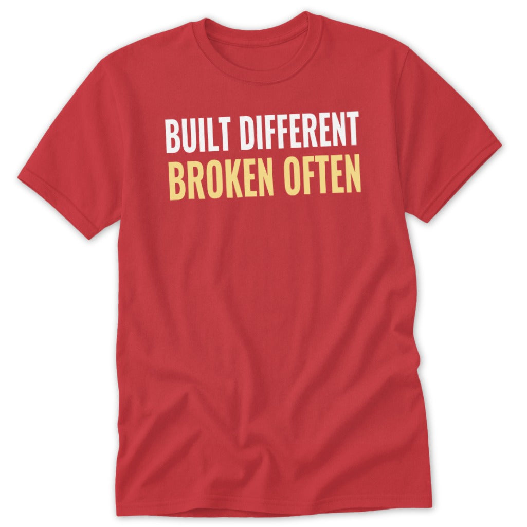 Red t-shirt with white text "BUILT DIFFERENT" and yellow text "BROKEN OFTEN".