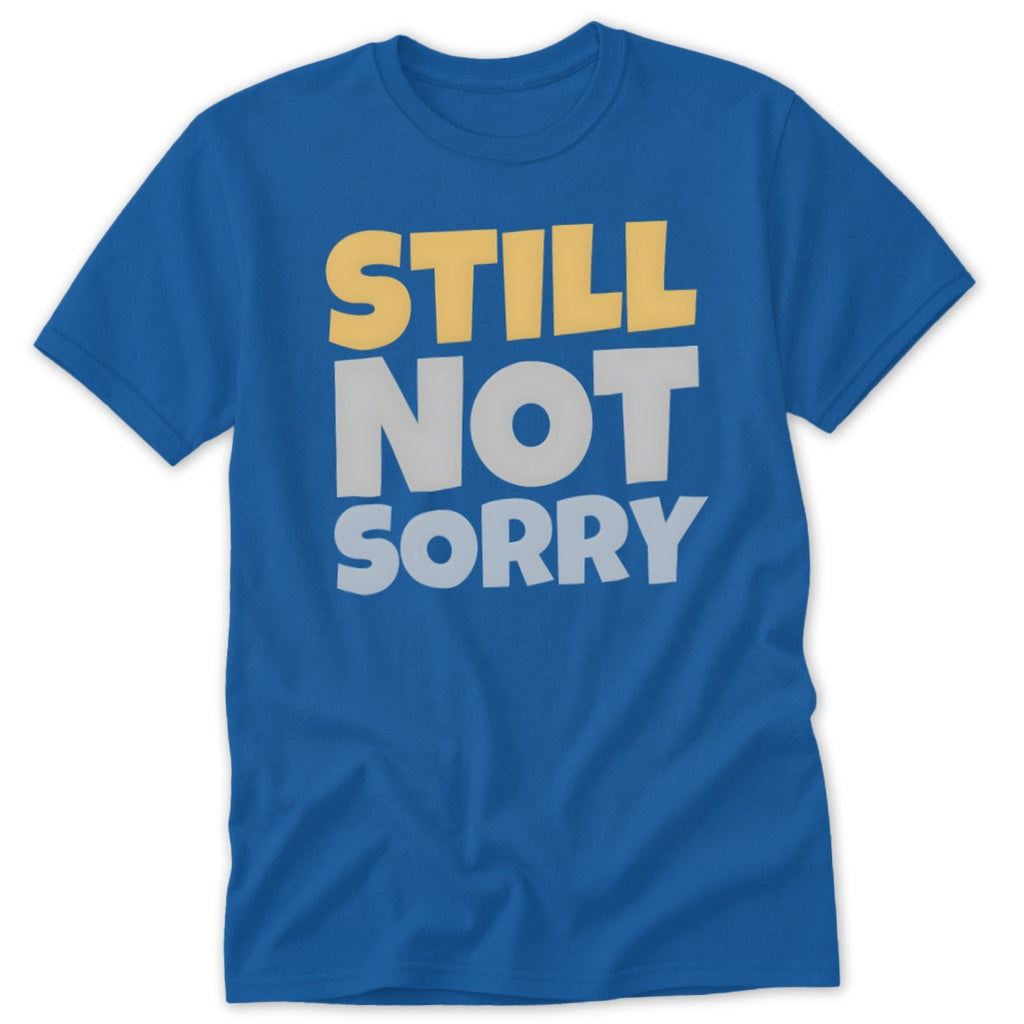 Blue t-shirt featuring the text "STILL NOT SORRY" in yellow and grey block letters.