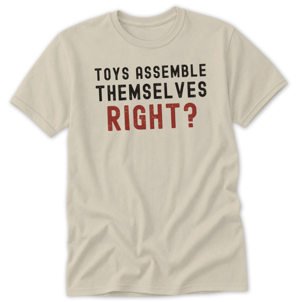 Cream t-shirt with black and red text that reads "TOYS ASSEMBLE THEMSELVES RIGHT?"
