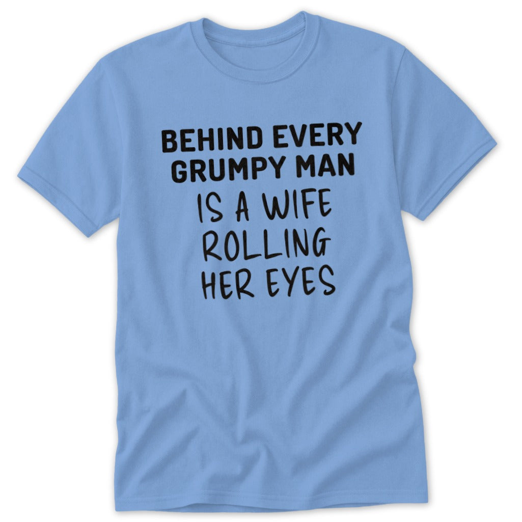 Light blue t-shirt with black text that reads "Behind every grumpy man is a wife rolling her eyes."