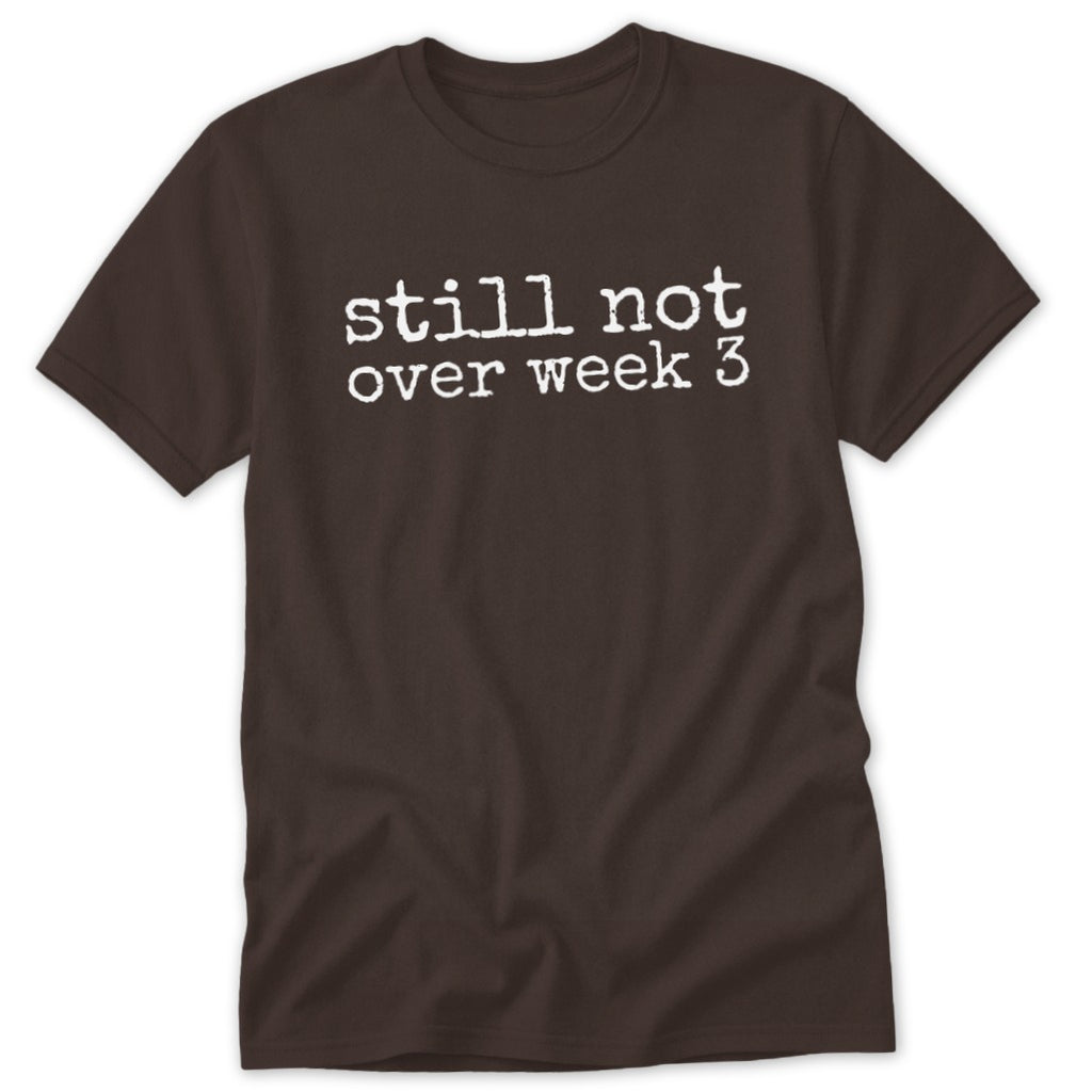 A brown short-sleeved t-shirt with the white text still not over week 3 printed centrally on the chest.