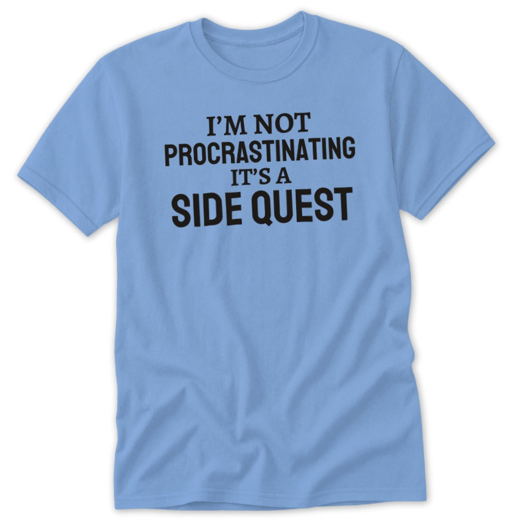 Light blue t-shirt with black text reading "I'M NOT PROCRASTINATING IT'S A SIDE QUEST".