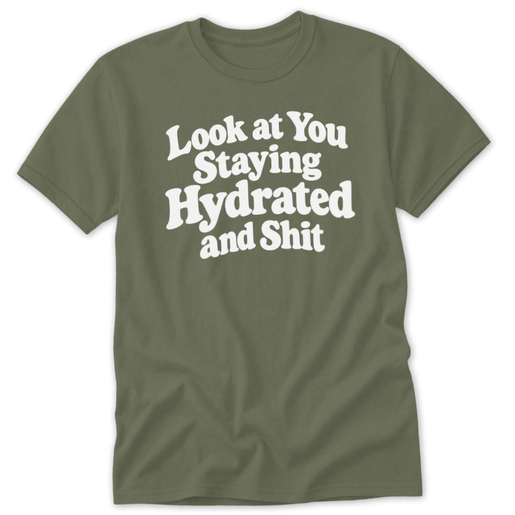 An olive green t-shirt with white text reading "Look at You Staying Hydrated and Shit".