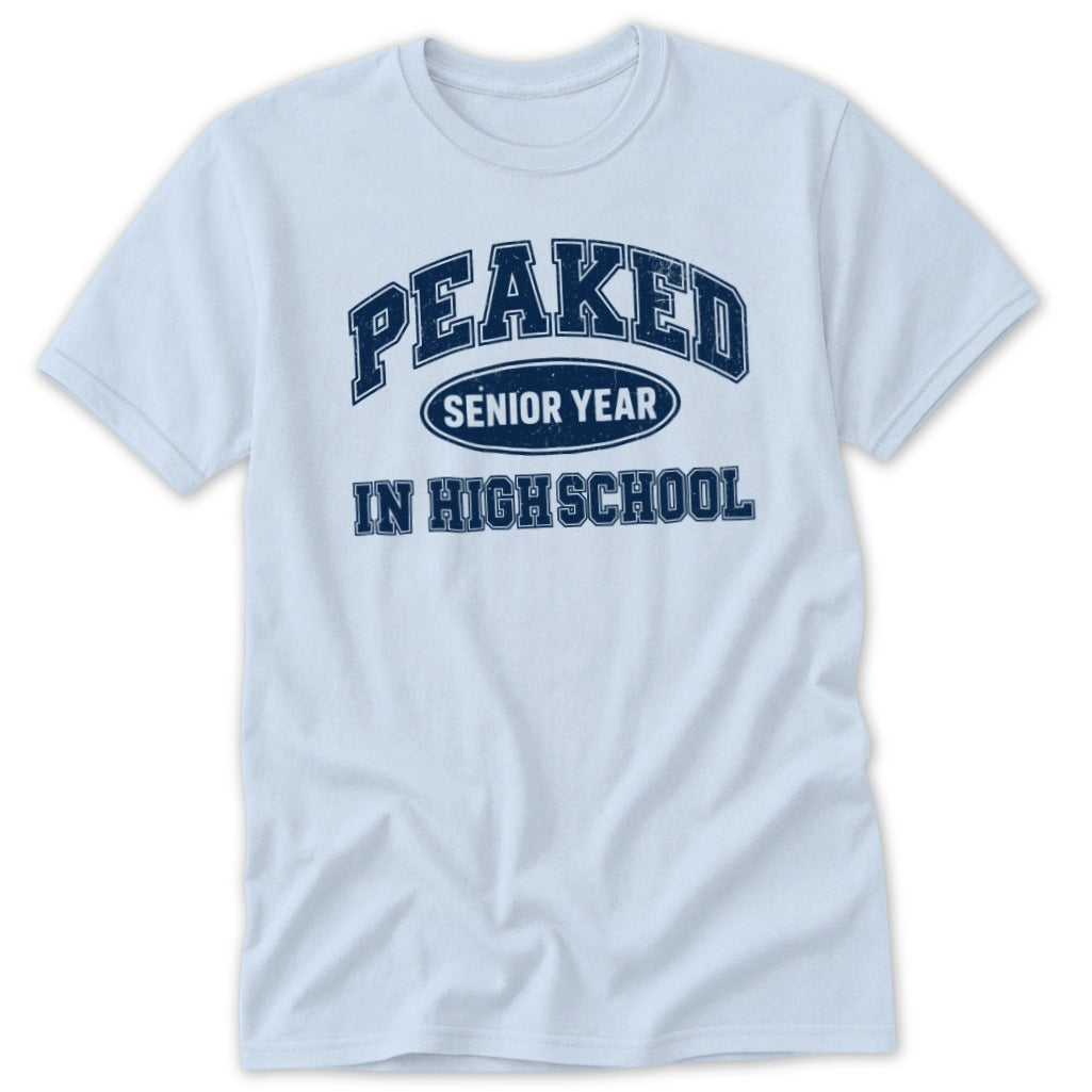 Light blue t-shirt with navy blue "PEAKED SENIOR YEAR IN HIGH SCHOOL" graphic.