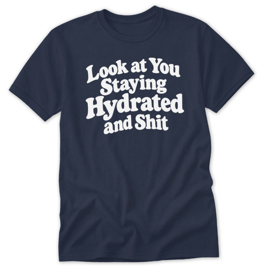 A navy blue short-sleeved t-shirt features white text reading "Look at You Staying Hydrated and Shit."
