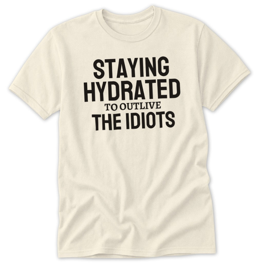 Cream t-shirt with black text that says "STAYING HYDRATED TO OUTLIVE THE IDIOTS".