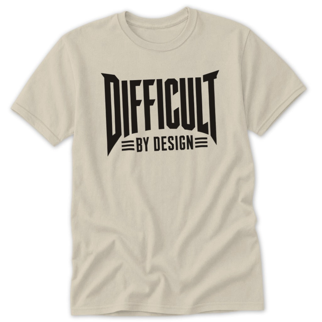 Light beige short-sleeved crew neck t-shirt featuring bold black text reading DIFFICULT BY DESIGN across the chest.