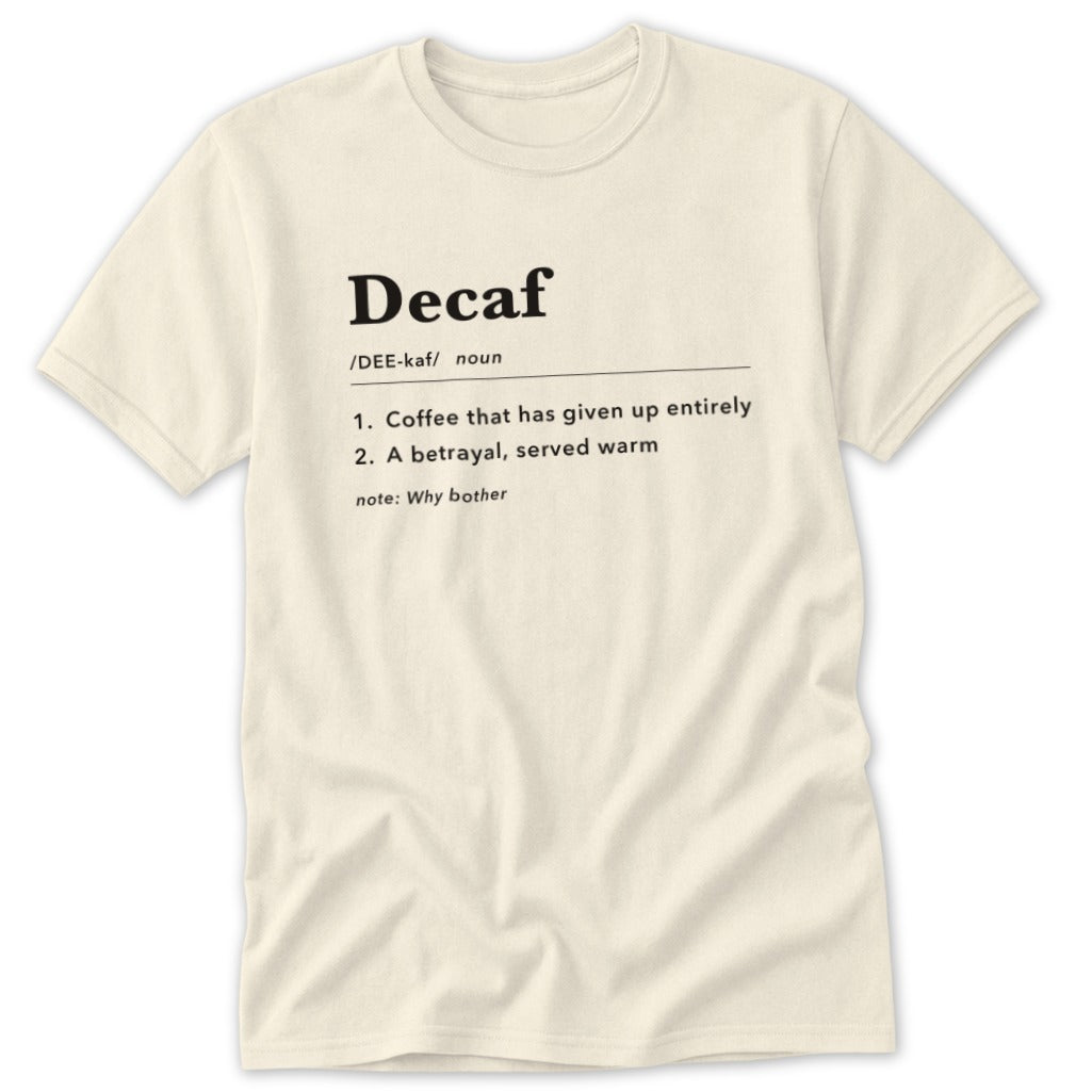 Cream t-shirt with "Decaf" definition: coffee betrayal, served warm.