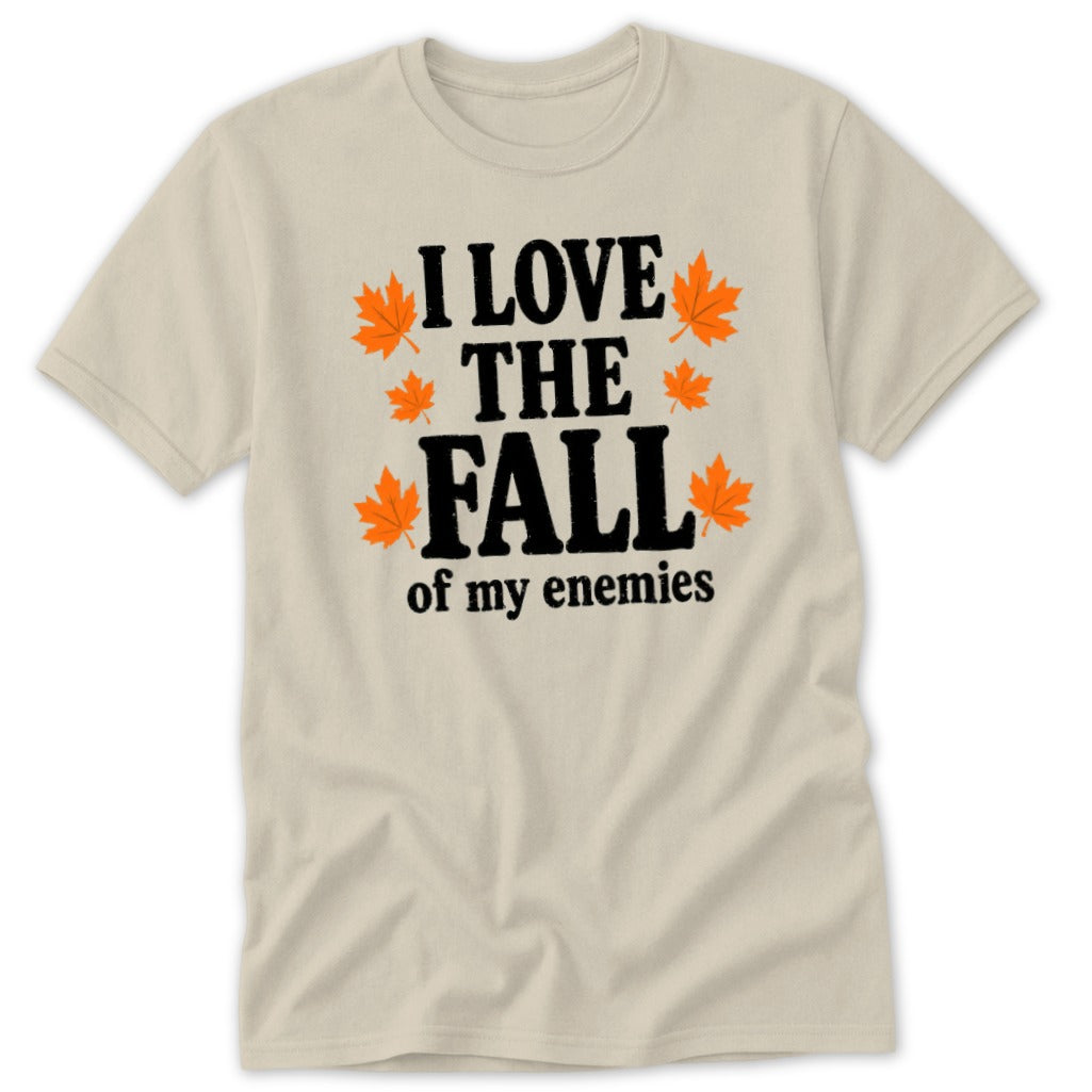 Light beige t-shirt with black text "I LOVE THE FALL of my enemies" and orange leaves.