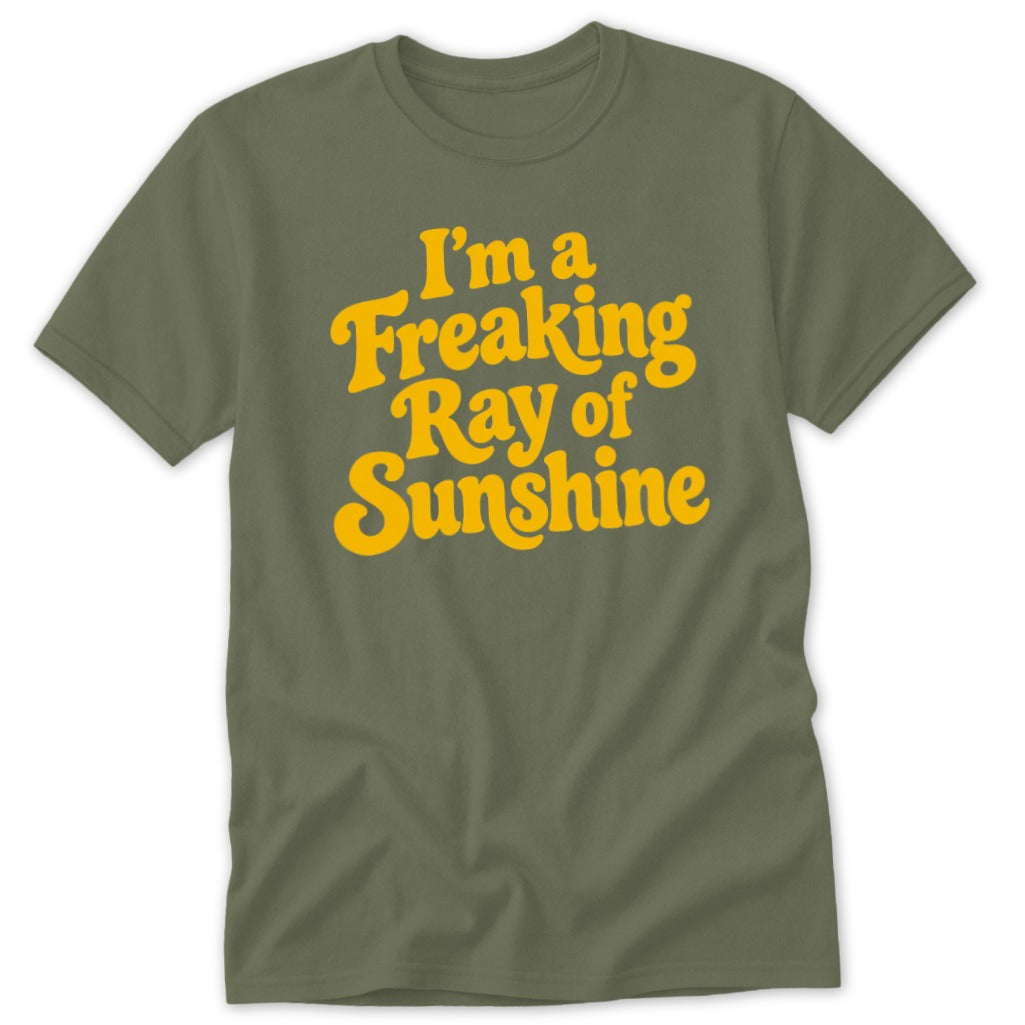 An olive green crewneck t-shirt with yellow text reading I am a Freaking Ray of Sunshine.
