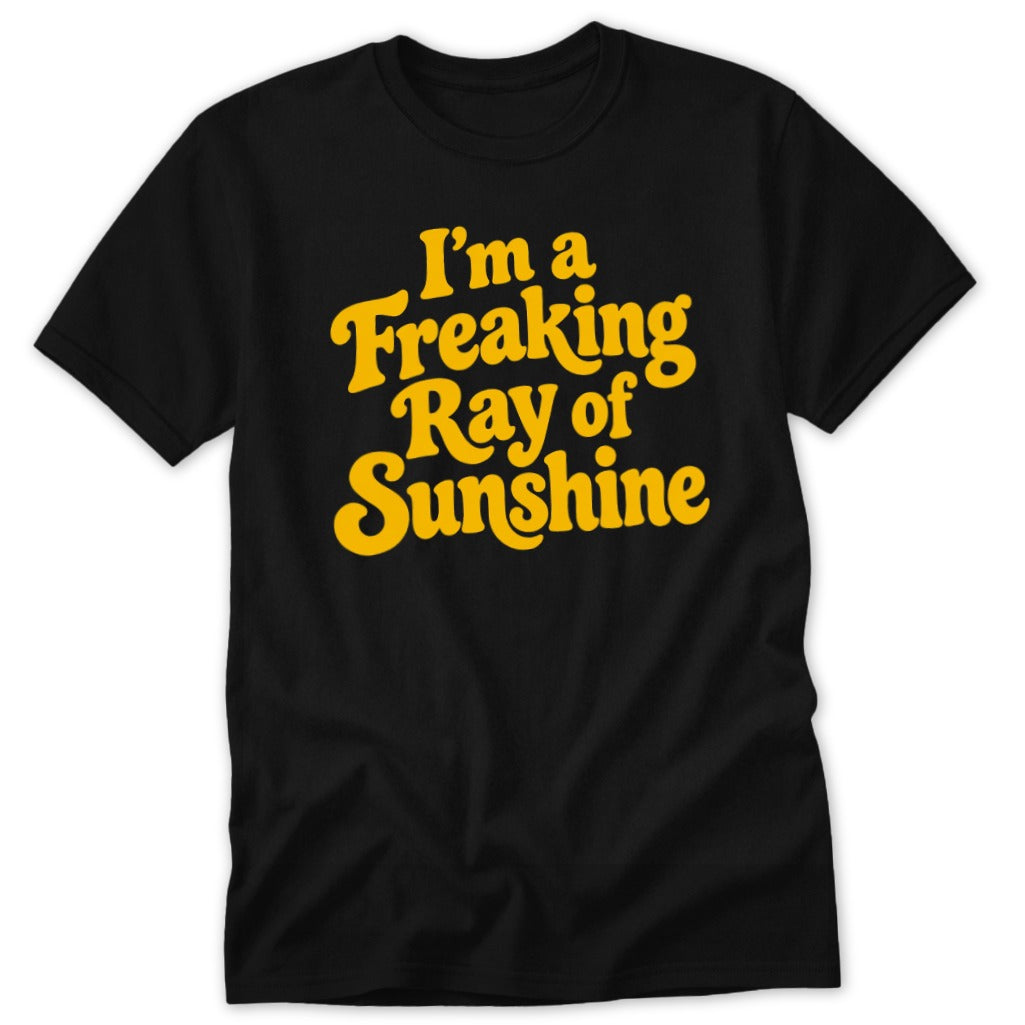 A black short-sleeve t-shirt with yellow text reading I'm a Freaking Ray of Sunshine.