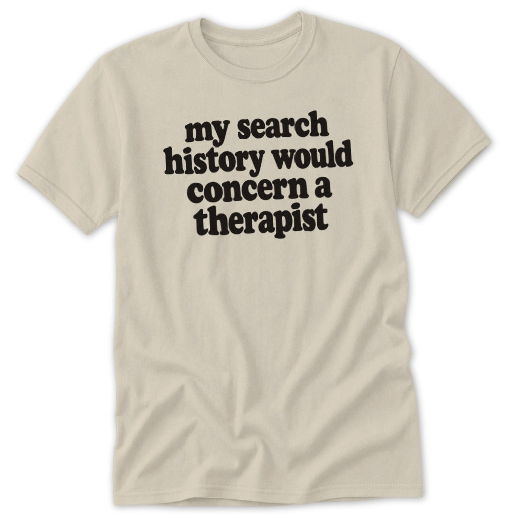 A beige short-sleeved t-shirt with the black text "my search history would concern a therapist" printed centrally.