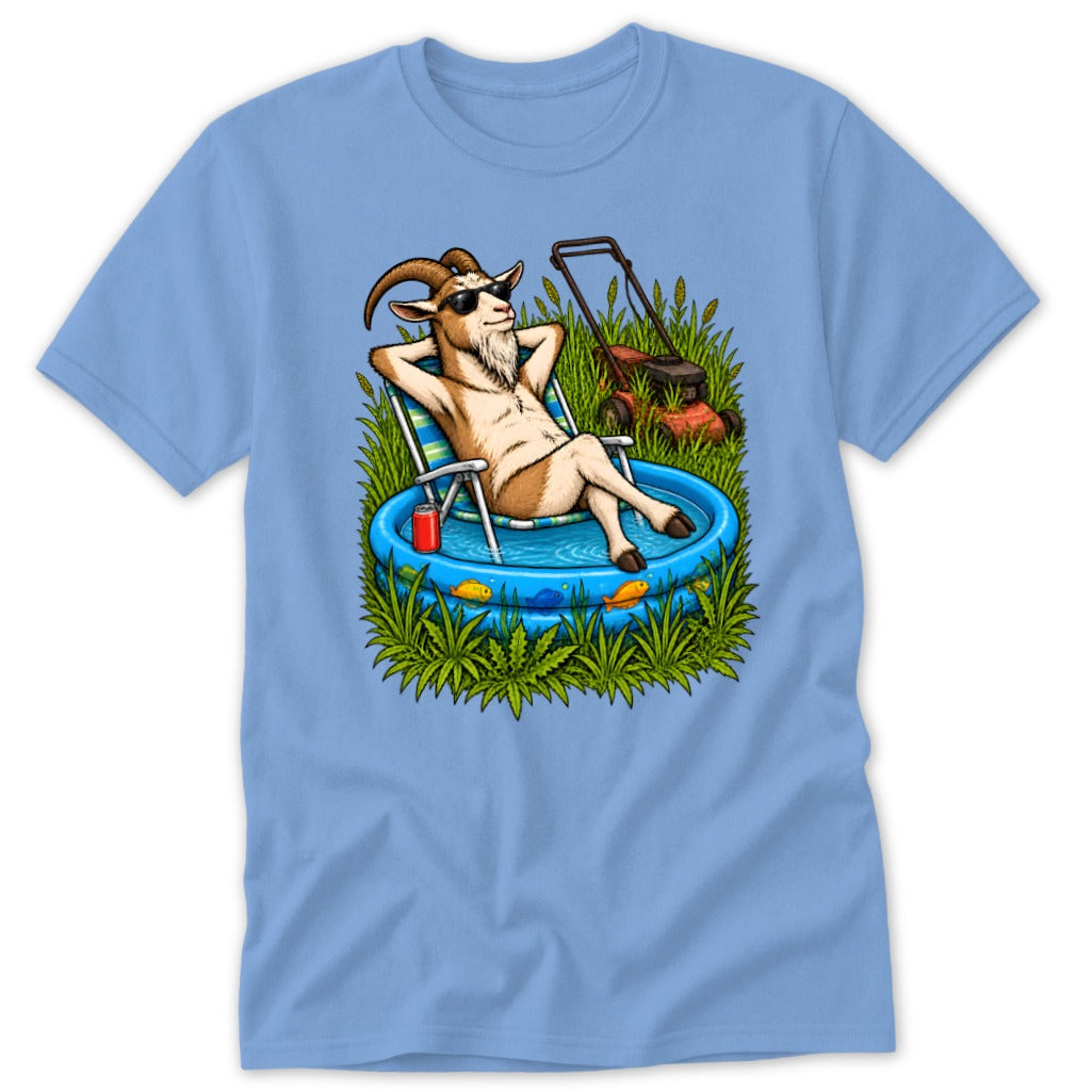 Goat relaxing in a kiddie pool next to a lawnmower in tall grass.