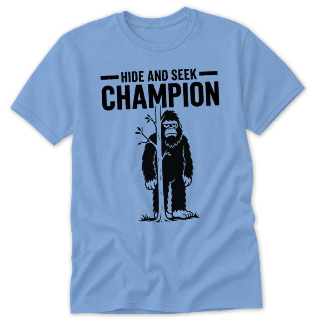 Light blue t-shirt with Bigfoot behind a tree, text "Hide and Seek Champion".
