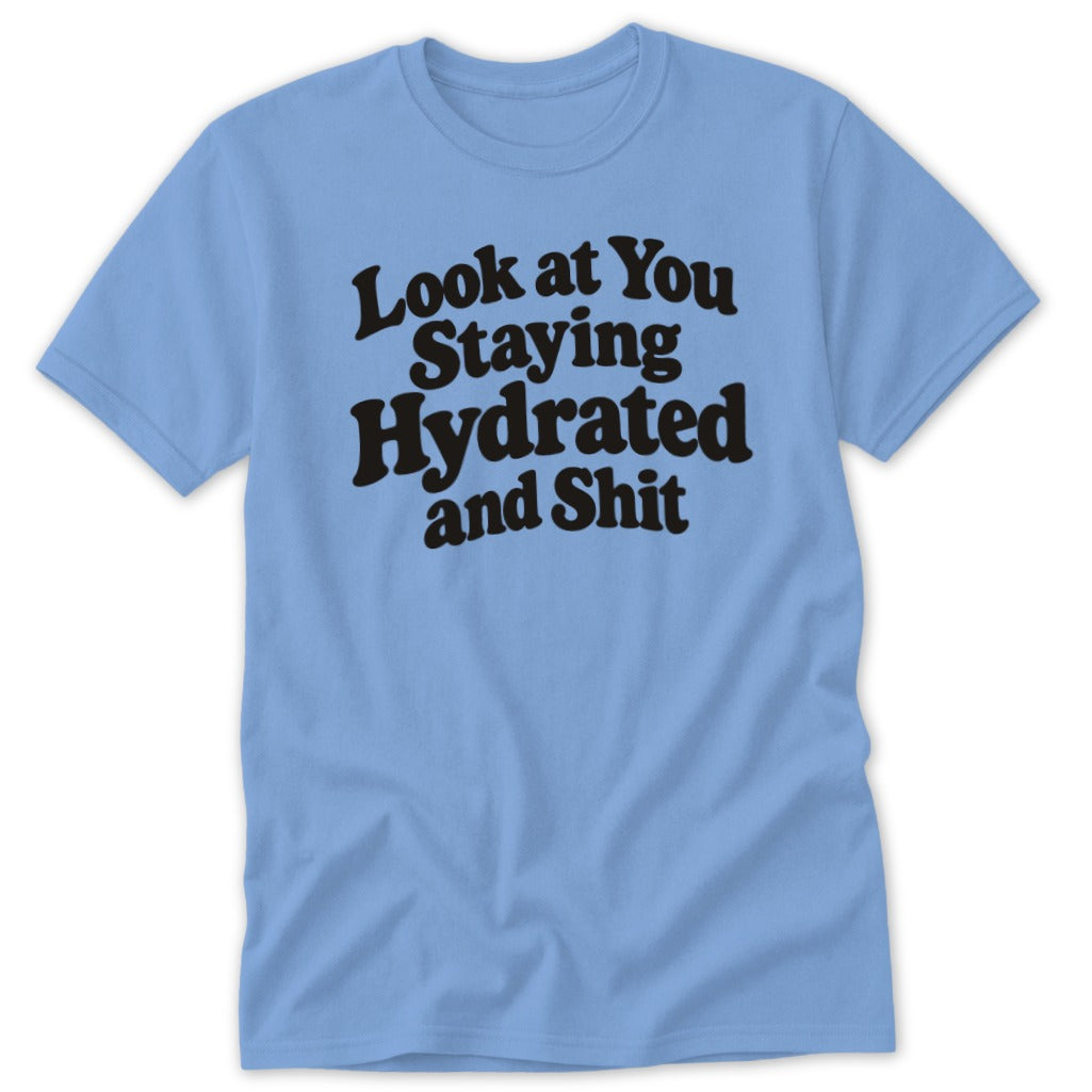 Light blue t-shirt featuring black retro typography with the text Look at You Staying Hydrated and Shit.