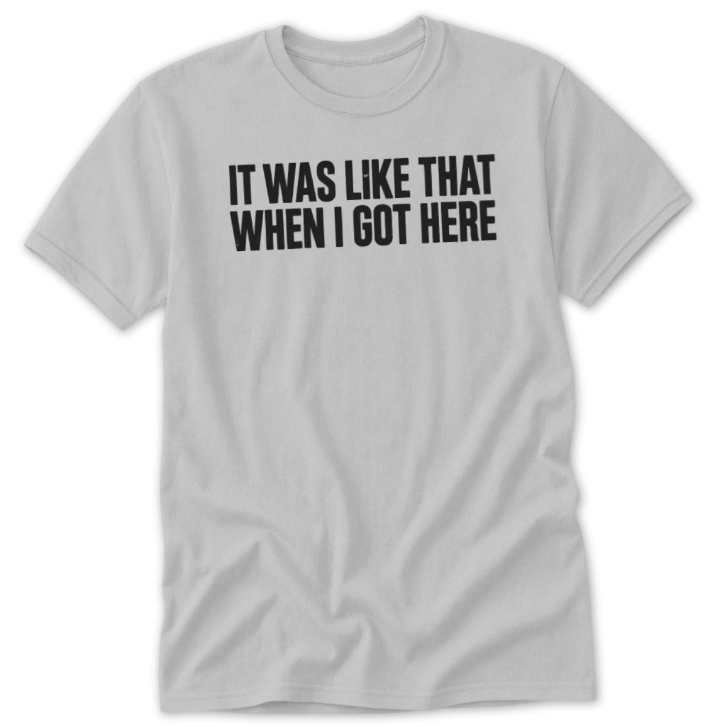 Light grey t-shirt with black text reading "IT WAS LIKE THAT WHEN I GOT HERE".