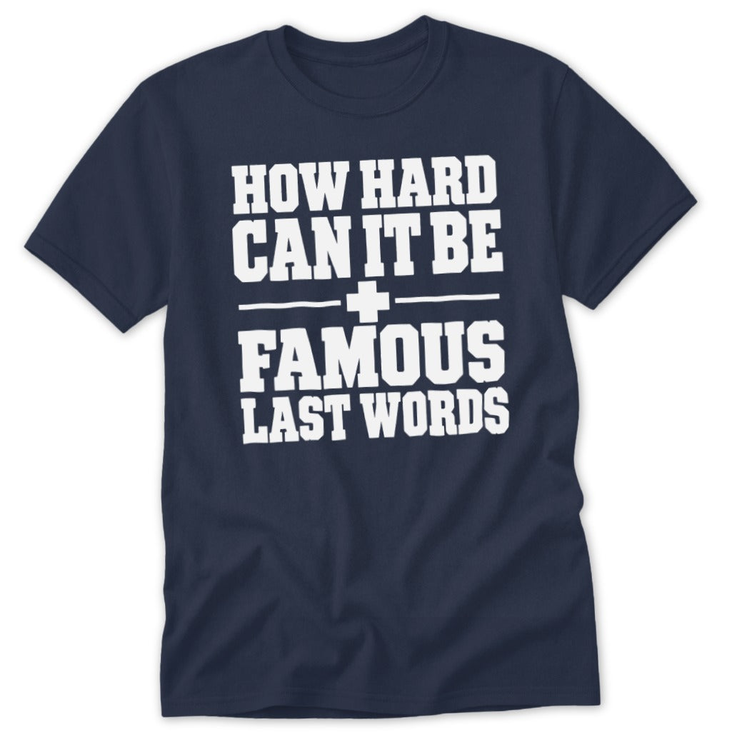 A dark blue crewneck t-shirt with white block text reading "HOW HARD CAN IT BE + FAMOUS LAST WORDS".