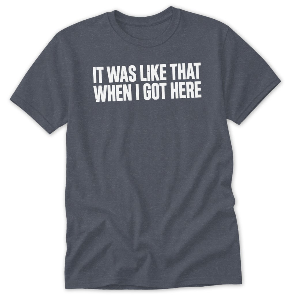 Dark heather t-shirt with white text "IT WAS LIKE THAT WHEN I GOT HERE".