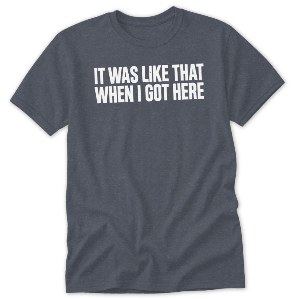 Dark heather t-shirt with white text "IT WAS LIKE THAT WHEN I GOT HERE".